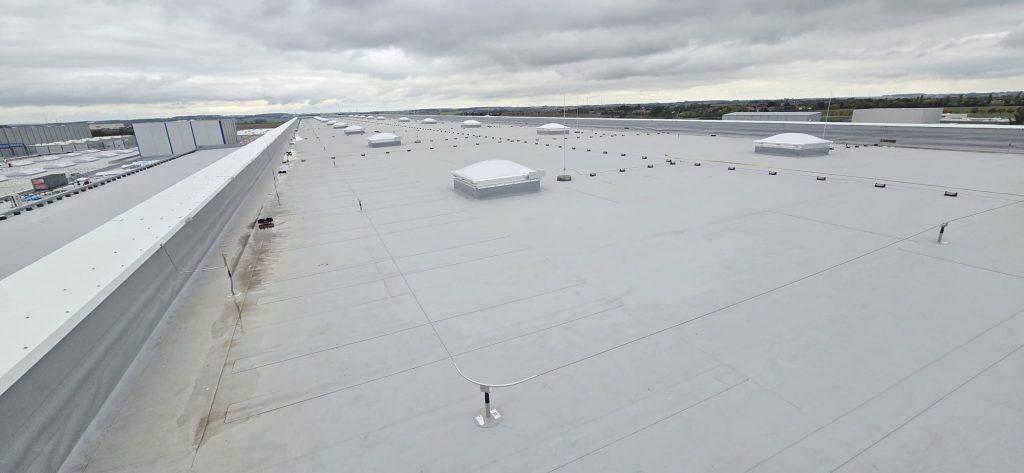 Eine weitläufige Fabrik mit zahlreichen weißen Dächern und einem markanten Hauptgebäude.