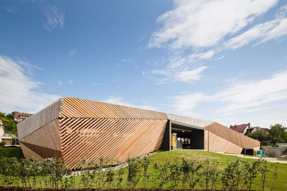 Ein Holzgebäude mit einer Fassade aus Naturholz, das sein rustikales und umweltfreundliches Design zur Schau stellt.